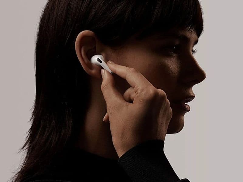 Person wearing AirPods Pro 3 walking on a city sidewalk