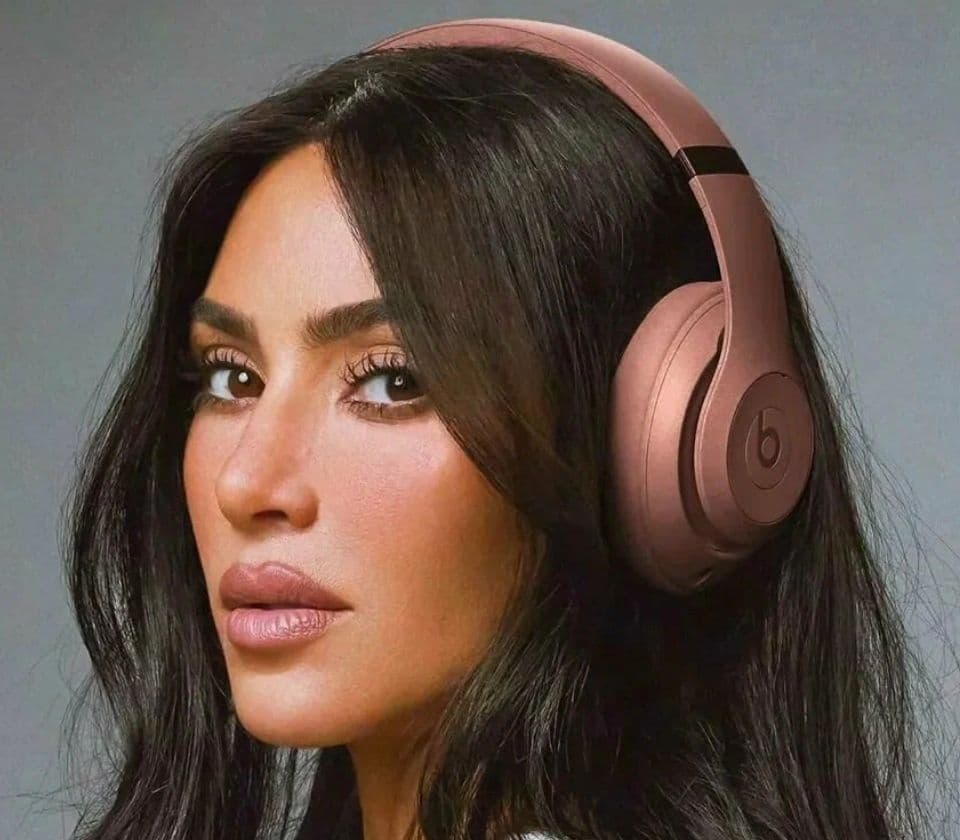 Person wearing Beats Studio Pro over-ear headphones in rose gold
