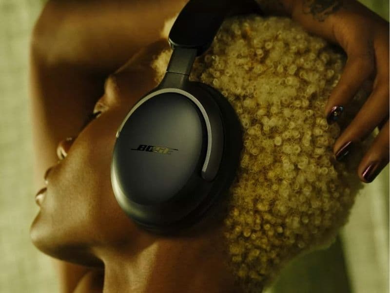 Person wearing Bose QuietComfort Ultra Headphones at a home desk