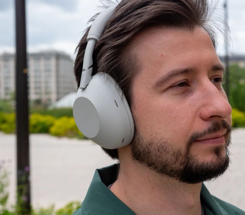 Commuter wearing Sony WH-1000XM6 noise-cancelling headphones outdoors